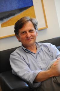 Photo of Ian Lipkin sitting on a couch.